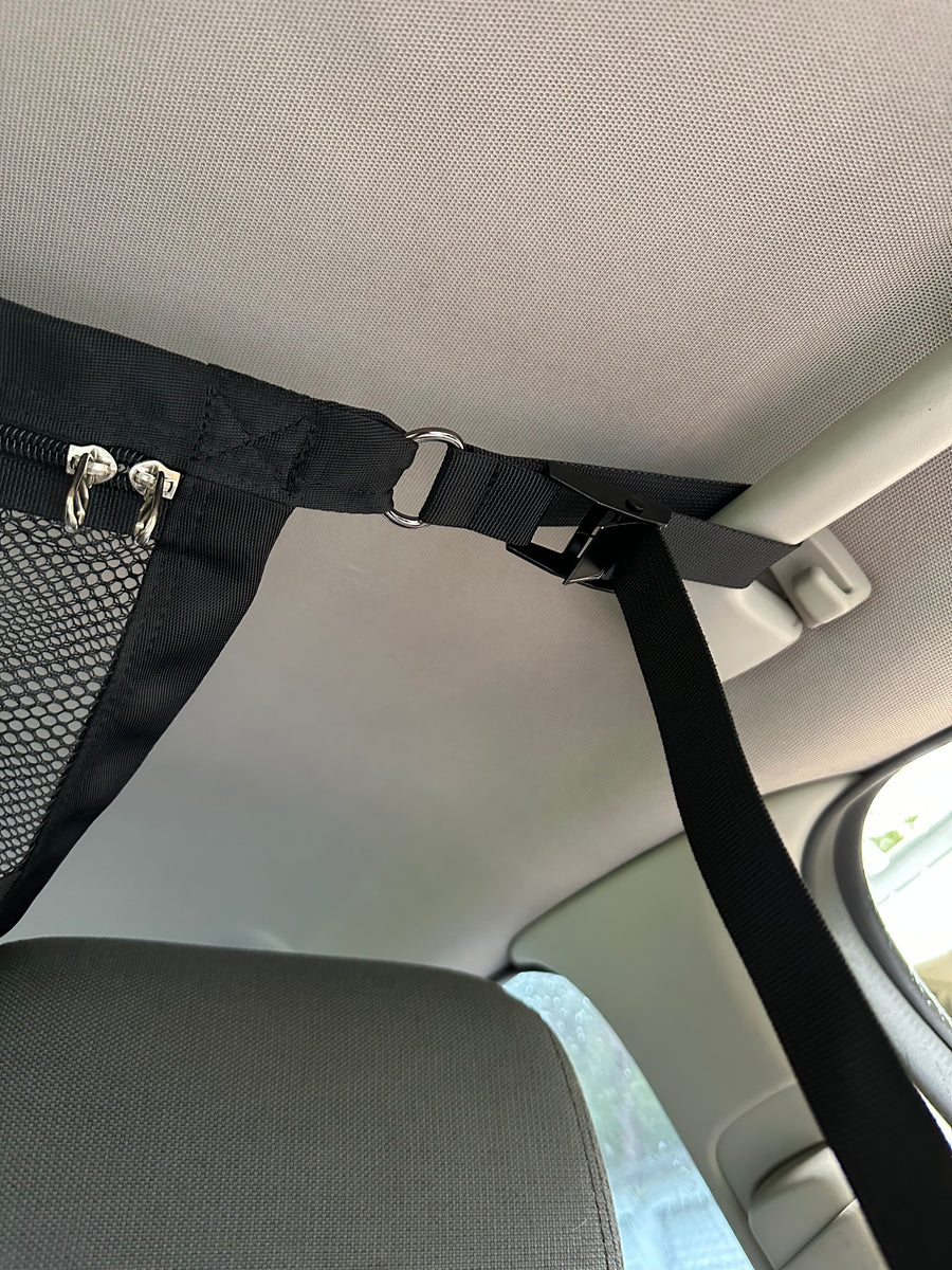 ZBAD1 cargo net strap and cam buckle clipped to a grab handle on a 4WD interior ceiling