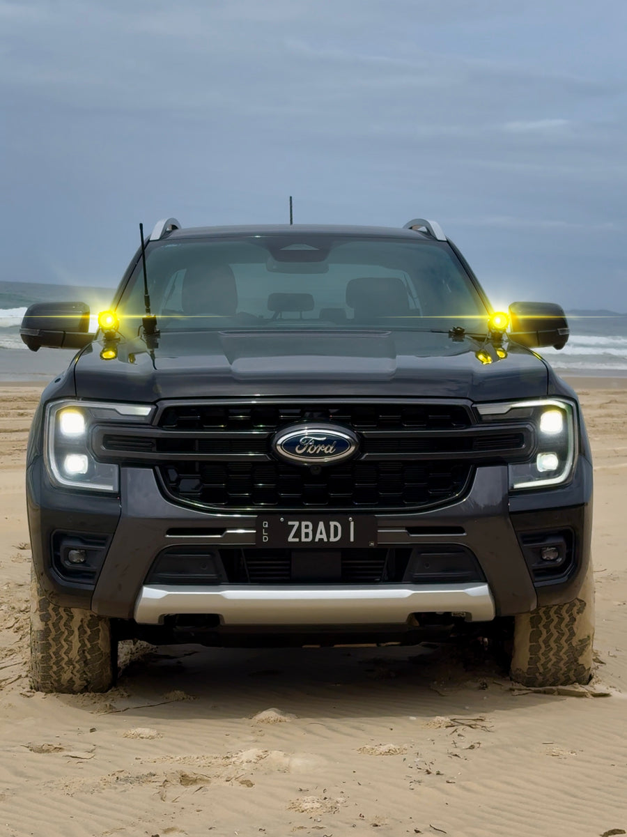 Ford Ranger on the beach with ZBAD1 amber lights glowing on both mirror mounts