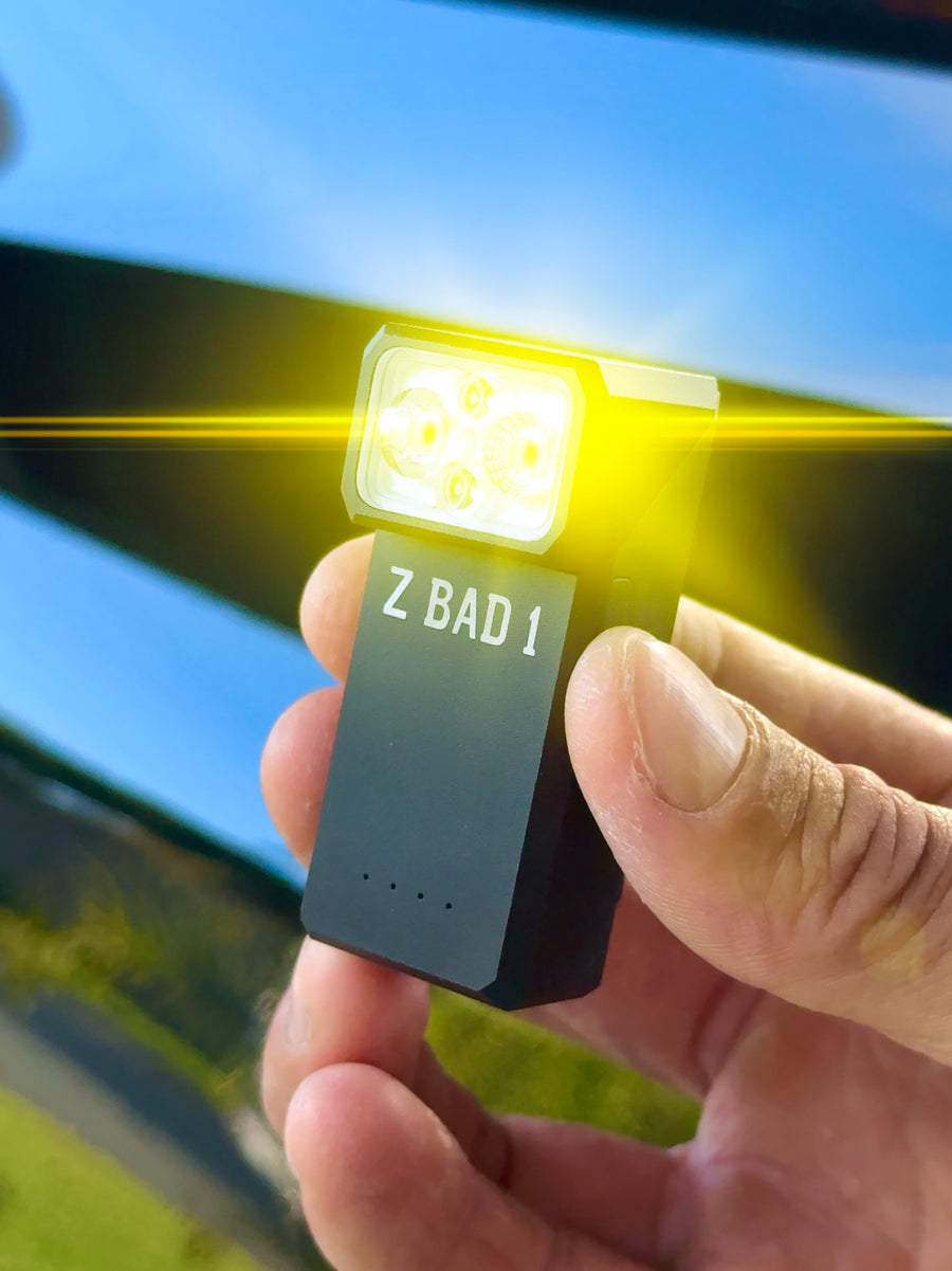 ZBAD1 magnetic multi torch held in hand with the amber light mode glowing