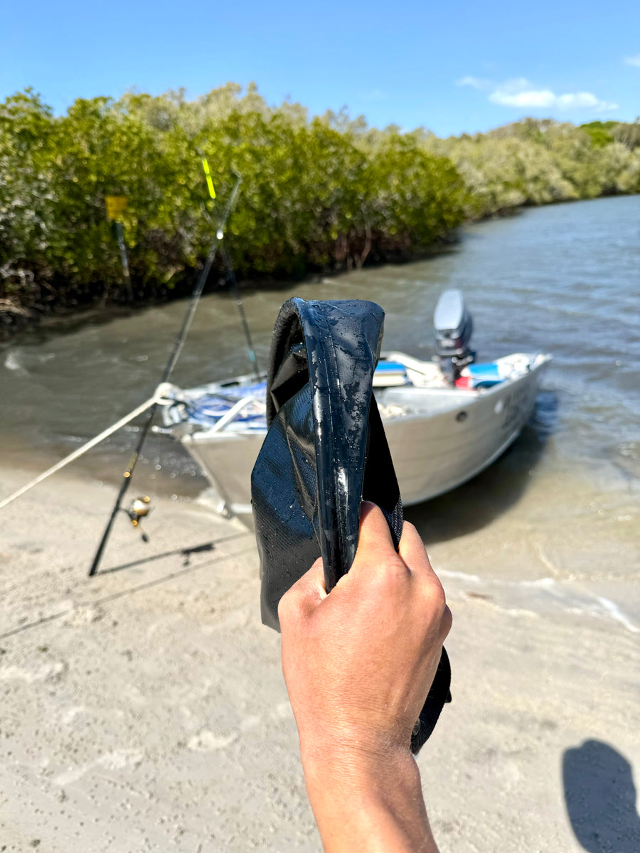 ZBAD1 flexi stowaway bucket folded flat and held in one hand by the water