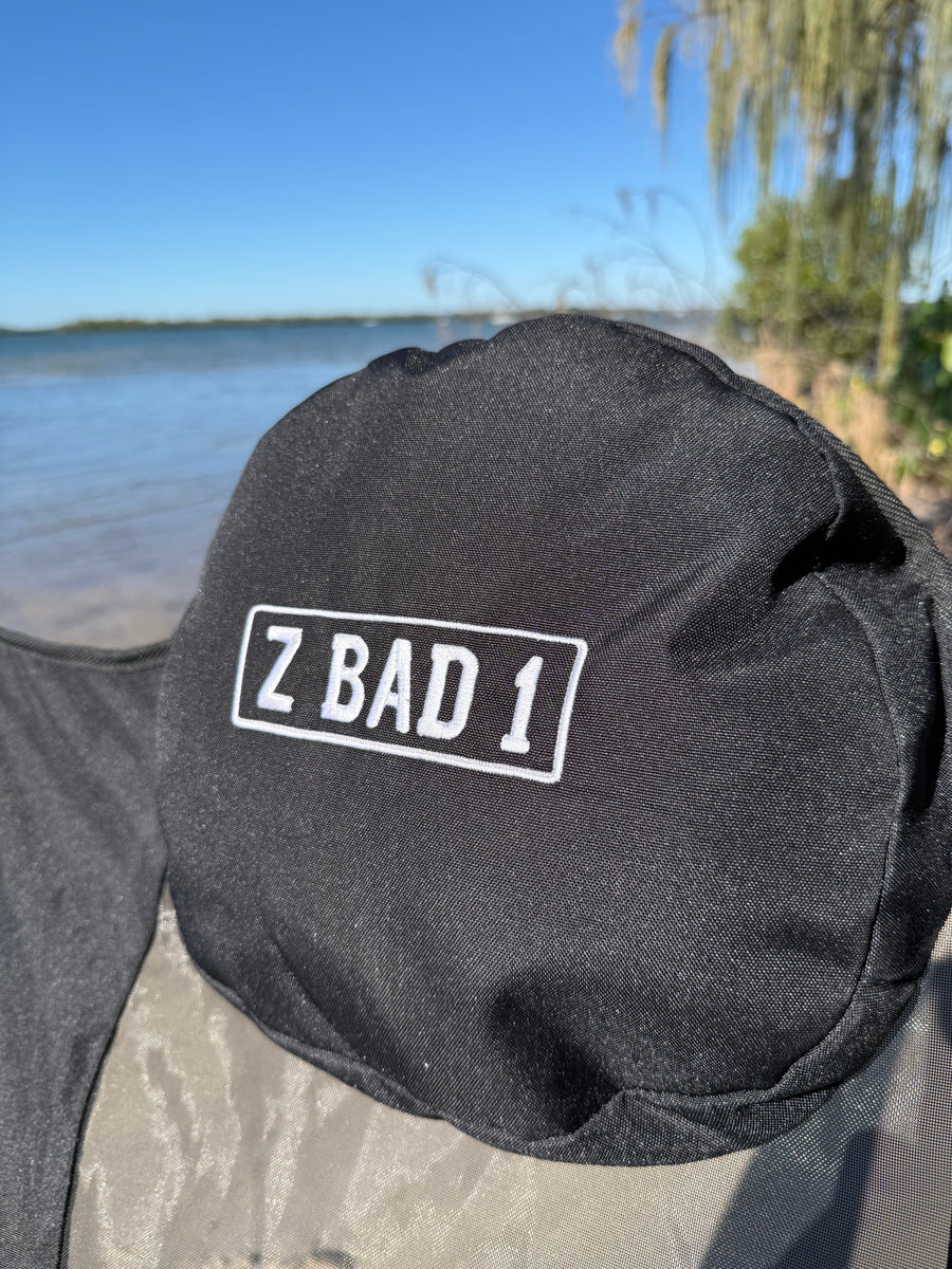 Embroidered ZBAD1 headrest pillow on the 360 spinning camp chair at the beach