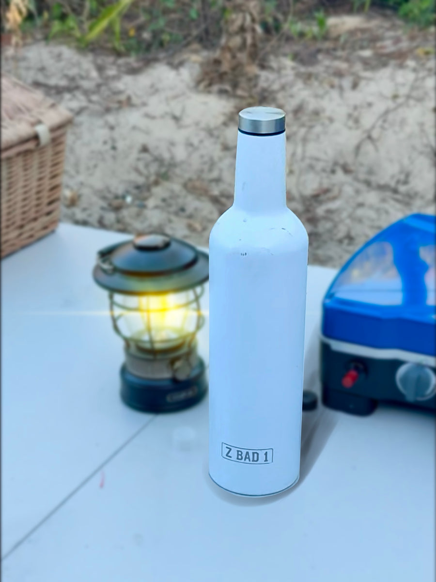White ZBAD1 insulated flask on a camp table beside a lantern and camping stove