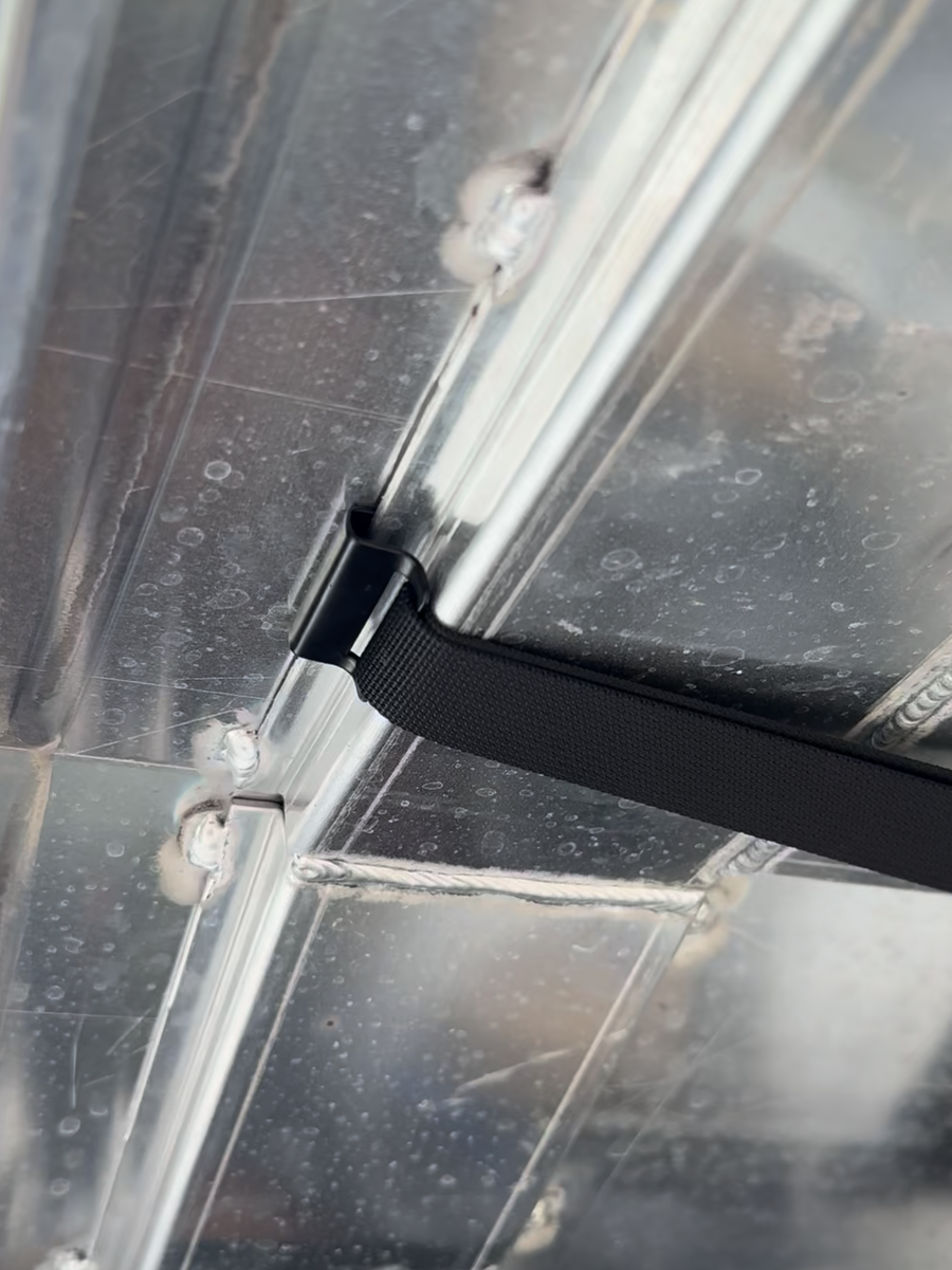 ZBAD1 storage net strap looped around the internal roof frame of an aluminium ute canopy