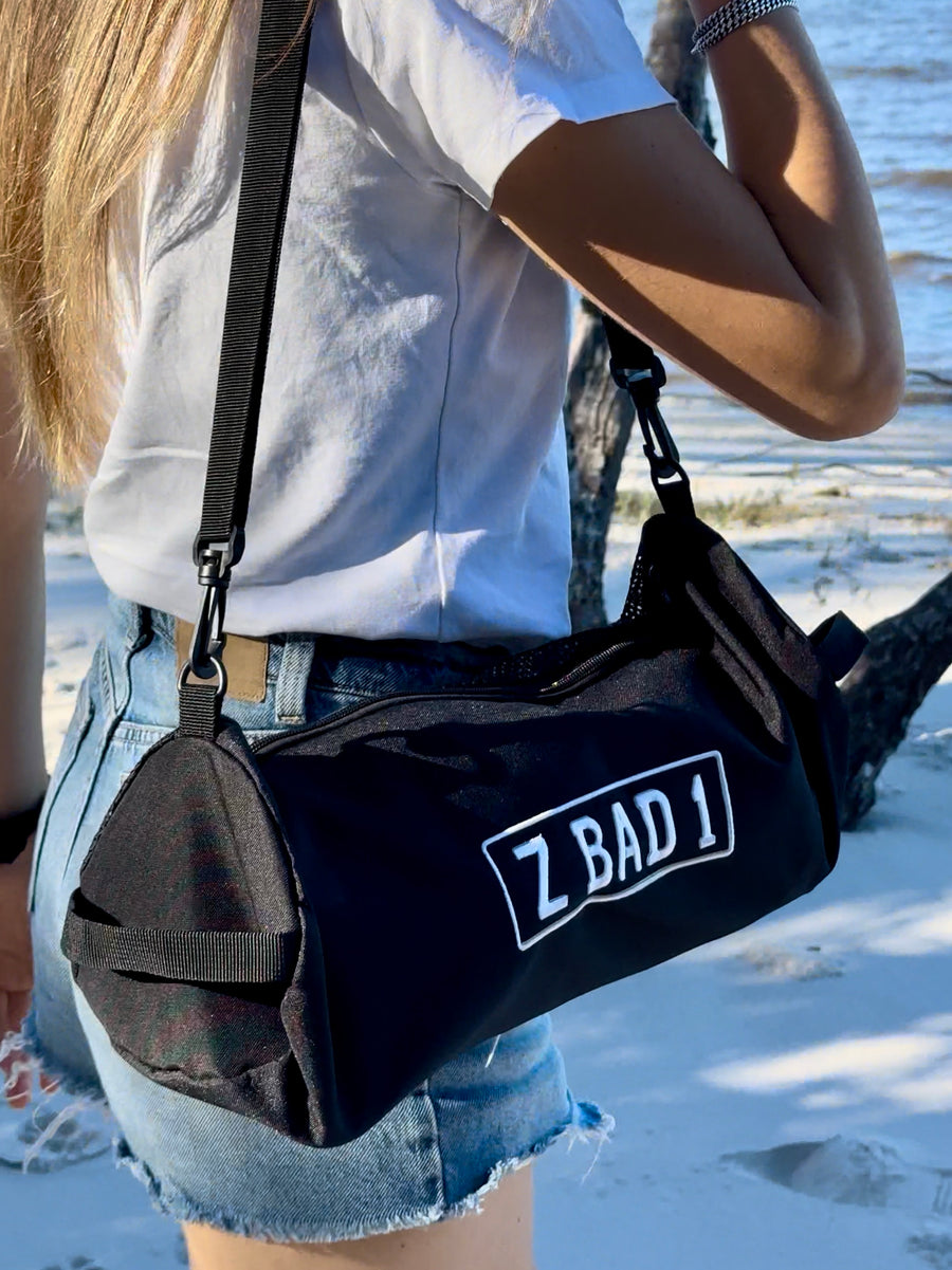 ZBAD1 360 spinning camp chair packed in its carry bag, worn over the shoulder at the beach