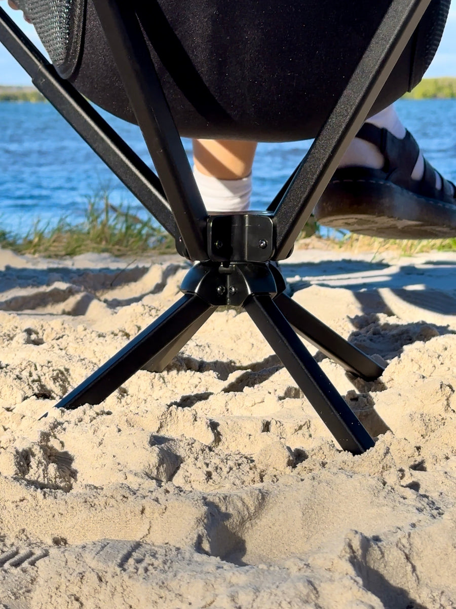 Swivel base of a ZBAD1 360 spinning camp chair on the sand by the water