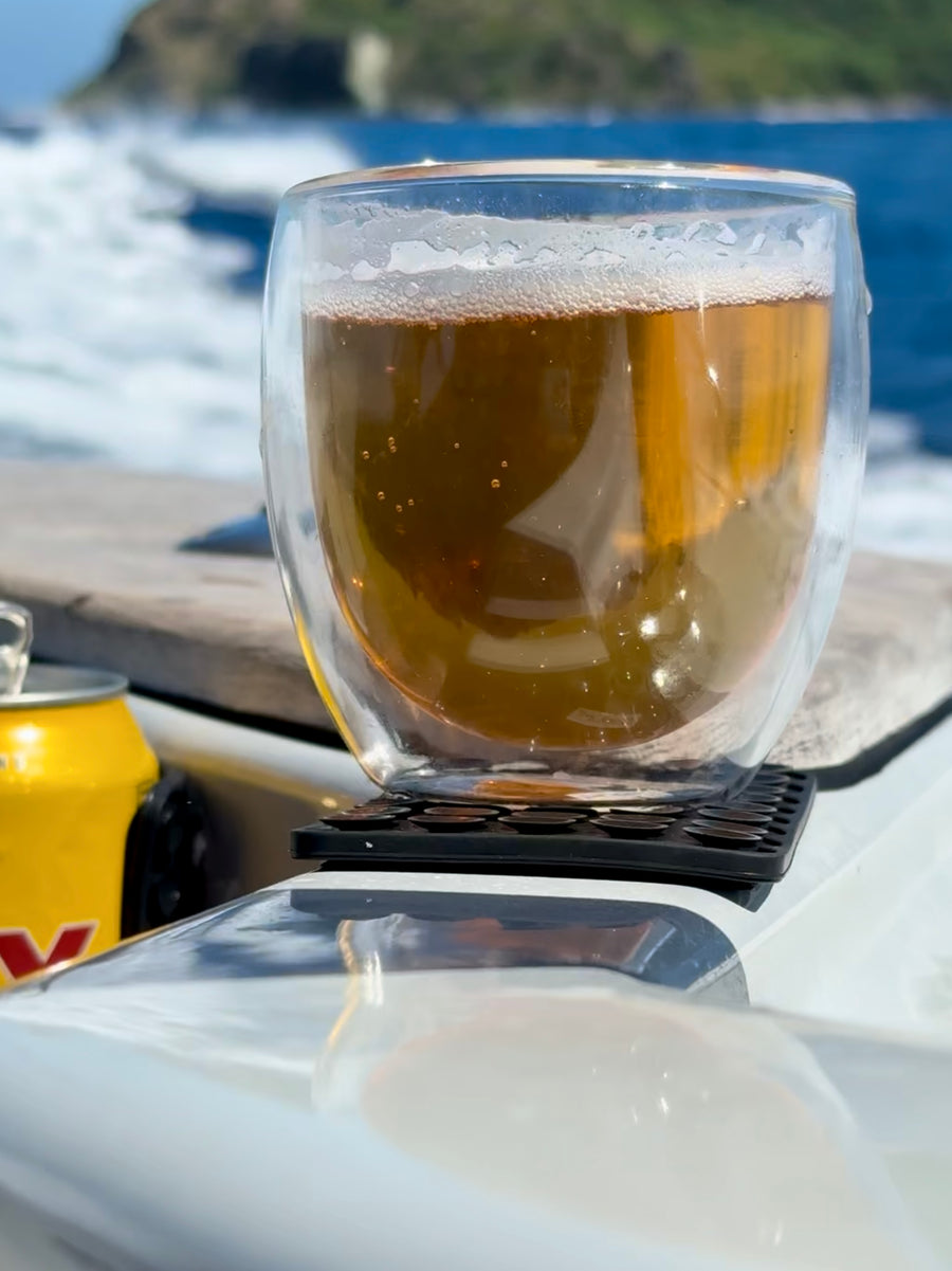 Glass of beer held steady on a black ZBAD1 grip mat on a boat